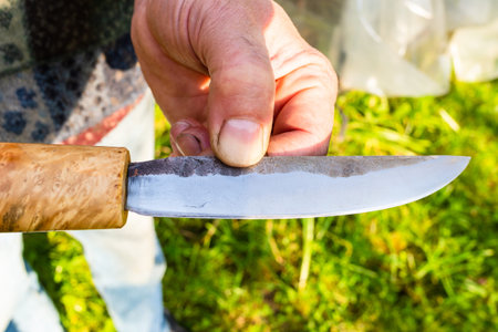 hand forged steel knife with wooden handle close up