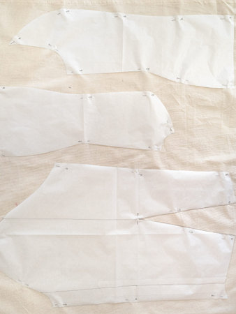 top view of paper pattern layouts of dress on calico fabric