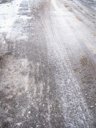 slippery ice-covered city road after freezing rain on cold autumn dayの写真素材