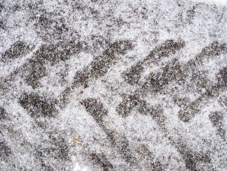 top view of frozen tractor tire imprint on ice-covered road close up after freezing rain on cold autumn dayの写真素材