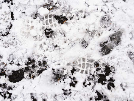 top view of footprints in the first snow on surface of outdoor playground on cold autumn dayの写真素材