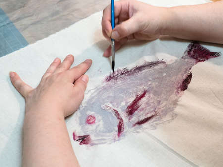 masterclass for Fish Drawing in Technique Monotype - finishing fish print on fabric with painbrushの写真素材