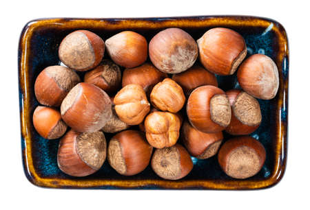 top view of ripe hazelnuts in bowl cutout on white backgroundの写真素材