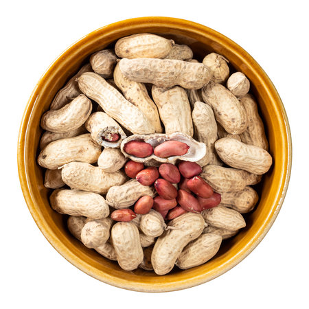 top view of peeled and unpeeled peanuts in round ceramic bowl cutout on white background