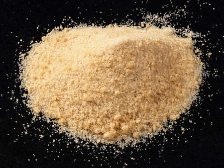 handful of granulated Coconut sugar closeup on black plateの写真素材