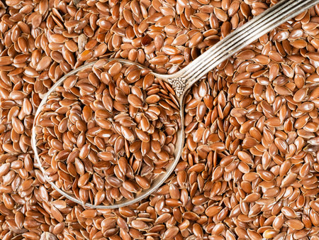 top view of silver tablespoon in brown flax seeds closeupの写真素材
