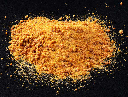 handful of granulated coconut blossom sugar closeup on black plateの写真素材