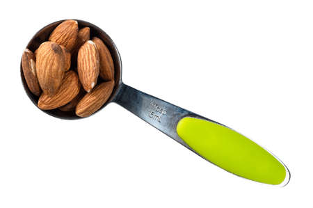 top view of almond seeds in measuring spoon cutout on white backgroundの写真素材