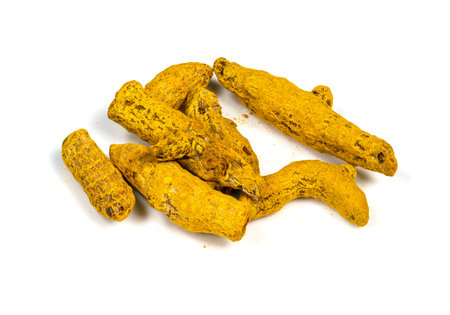 handful of dried roots of Turmeric (Curcuma Longa) closeup on white background