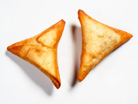 pair of Peruvian Empanadas (fried Turnover filled with meat) on white paper background