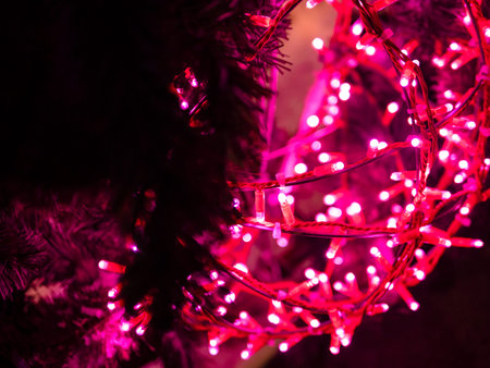 glowing pink street christmas garlands closeup (focus on the lamps on foreground)