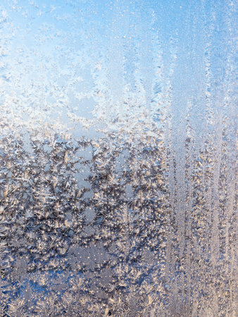 frost lit by sun on home window glass on cold sunny winter day