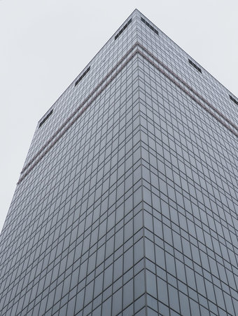 gray glass tower of skyscraper and gray sky on overcast day