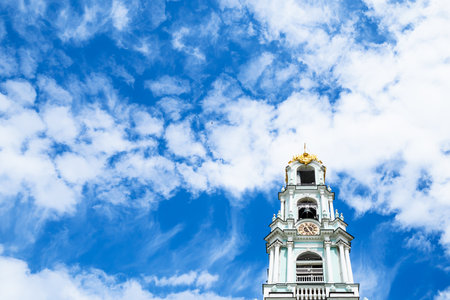 white clouds in blue sky over bell tower of orthodox churchの写真素材