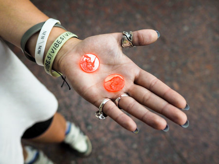 Yerevan, Armenia - August 26, 2023: top view of plastic tokens on palm of female tourist for travel on city metro in Yerevan city closeup on summer eveningのeditorial素材