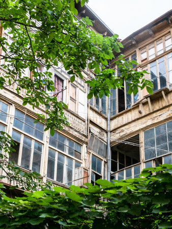 glazed wooden balconies on facades of old residential building in Tbilisi city on summer day, Georgiaの写真素材