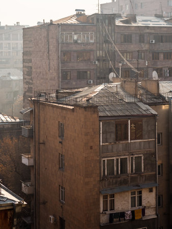 view of old apartment buildings in sunny morning with urban smog in Yerevan city in winterの写真素材