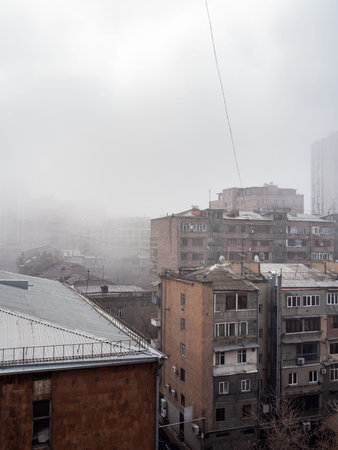 smoke, smog and fog over urban houses in Yerevan city in winter morning