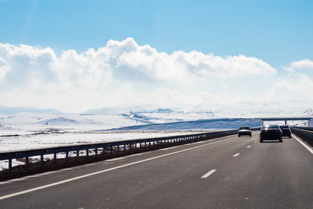M1 North-South highway at plain of Shirak Province of Armenia on sunny winter day (view through car windshield)の写真素材