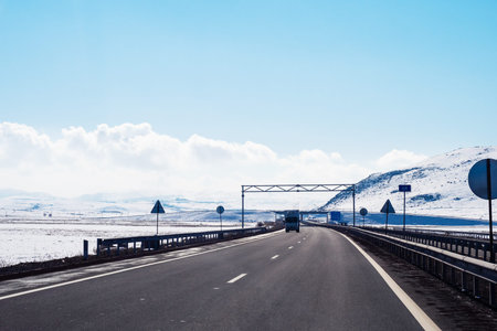 M1 North-South highway in Shirak Province of Armenia on sunny winter day (view through car...