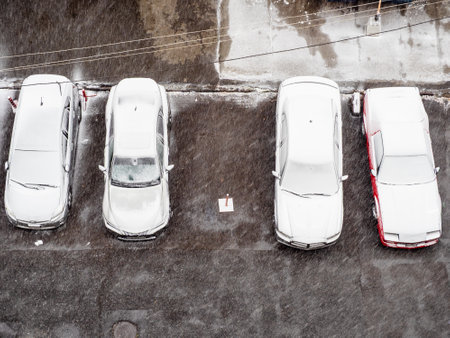 above view of snow covered parked cars in urban yard on winter day in Yerevan city, Armeniaの写真素材