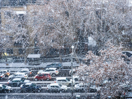 above view of car driving in snowfall on Mashtots Avenue on winter evening in Yerevan city, Armeniaの写真素材