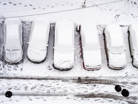 above view of snow-covered cars in urban courtyard after snowing on winter day in Yerevan city, Armeniaの写真素材