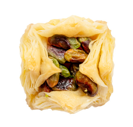 above view of piece of layered square baklava with pistachio nuts cut out on white backgroundの写真素材