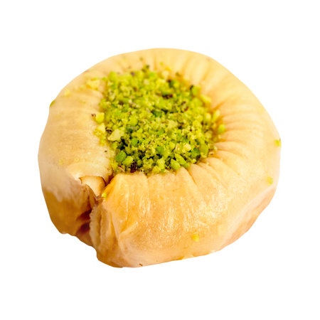 piece of round baklava with pistachio cut out on white backgroundの写真素材