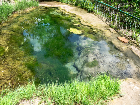 puddle with mineral water on path to Vorotan River from Devil's Bridge in mountain gorge, between villages of Tatev and Halidzor in Syunik Province of Armenia on sunny May dayの写真素材