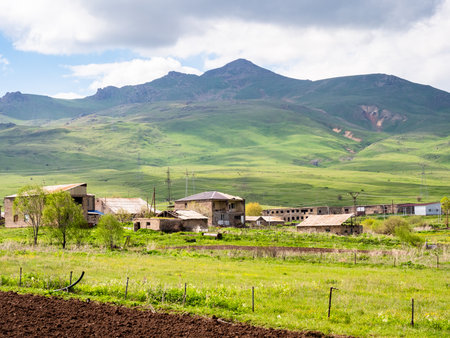 small village in green mountains along M9 highway in Syunik province of Armenia on cloudy May dayの写真素材