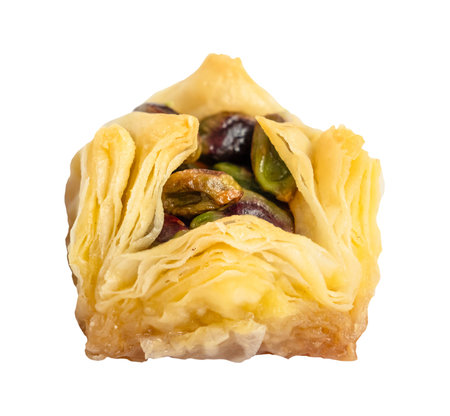 piece of layered square baklava with pistachio nuts cut out on white backgroundの写真素材