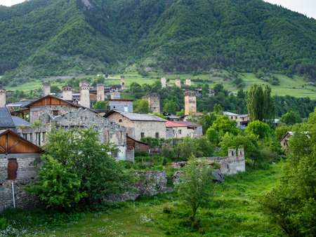 old houses in Mestia town on green mountain slope in Samegrelo-Zemo Svaneti province of Georgia in summer evening twilightの写真素材