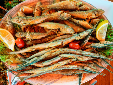 top view of various fried local Black Sea fishes on plate in outdoor fish market cafe in Batumi city, Georgiaの写真素材