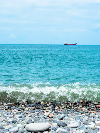 view of Black Sea with ship from pebble beach in Batumi city, Georgia on sunny summer dayの写真素材
