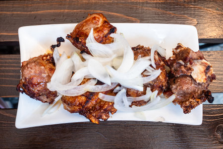 top view of Georgian lamb shashlik Mtsvadi on white plate on wooden table in outdoor local cafe in Borjomi town, Georgia on summer dayの写真素材