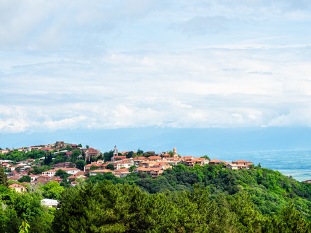 above view of Signagi town on top of mountain and large white cloud on horizon in background on summer morning, Georgiaの写真素材