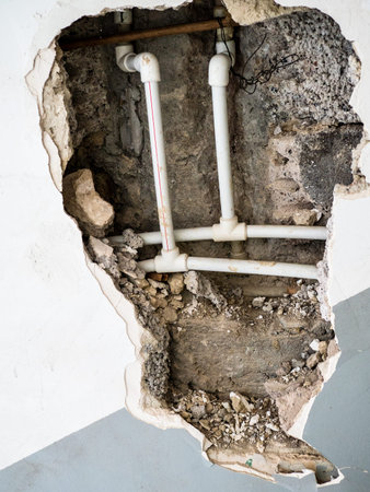 view of new plastic pipework in hole of broken wall of old apartment building in Yerevan city,...