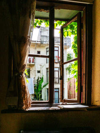view of house through window in old house in old Batumi city, Georgia on sunny summer day