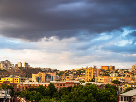 dark rainy clouds over residential district in Yerevan city, Armenia on summer eveningの写真素材