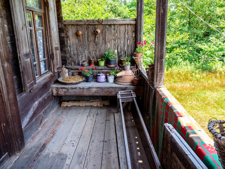 wooden veranda of shabby wooden house in old Sisa Tura village, in Chkhoria village, Samegrelo-Zemo Svaneti region of Georgia on sunny summer dayの写真素材