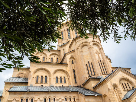green leaves and Holy Trinity Cathedral (Sameba) of Tbilisi city on overcast summer day, Georgia