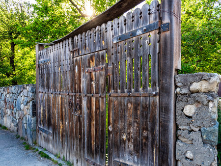 old wooden gates on street in Mestia town in Samegrelo-Zemo Svaneti province of Georgia on sunny summer dayの写真素材
