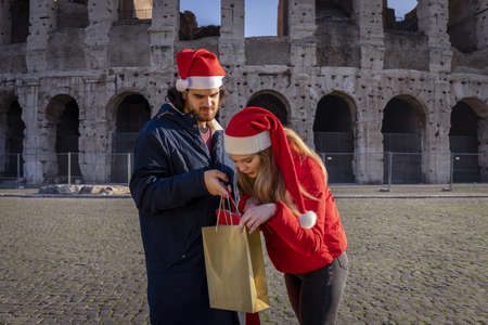 Christmas shopping time in Rome. Young couple checks the newly bought gifts.の写真素材