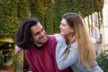 Young couple traveling to Rome. The beautiful blonde woman hugs her boyfriend and smiles. In the...