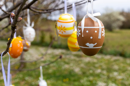 Happy Easter! Easter decorated eggs. Garden tree set up with multicolored Easter eggs.