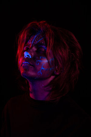 Young girl made up with fluorescent colors. Portrait of a beautiful girl with tribal designs...