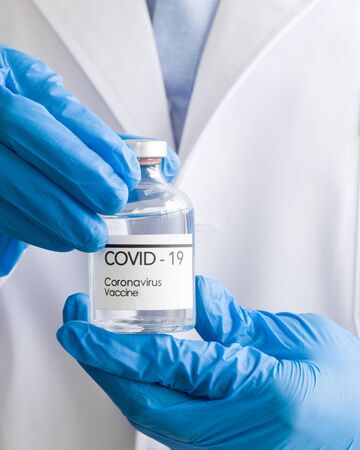 Bottle of coronavirus vaccine in the hands of doctors. Close upの写真素材