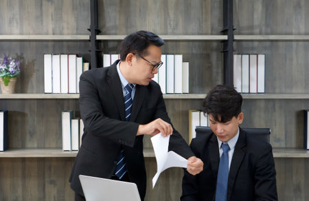 The asian manager blamed the staff and tore the documents apart. Morning work atmosphere in a modern office.の写真素材