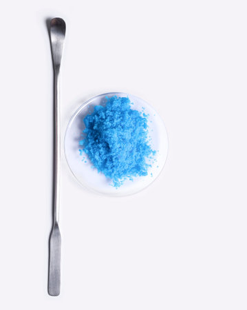 Copper(II) sulfate in Chemical Watch Glass placed next to the stirring rod on laboratory table.の写真素材